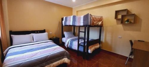 a bedroom with two bunk beds in a room at Hospedaje "LOS QUETZALES DE OXAPAMPA" in Oxapampa