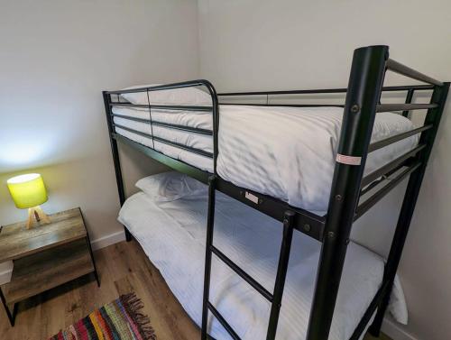 1 dormitorio con litera y mesa con lámpara en The Peaks 2, en Dadswells Bridge