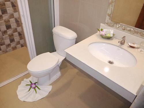 a white bathroom with a toilet and a sink at The Pano Hotel And Residence in Ban Khlong Haeng