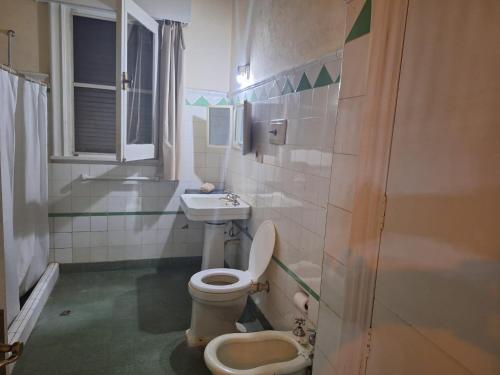 a bathroom with a toilet and a sink at Casona Harguindeguy in Paysandú