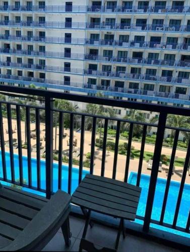 een balkon met 2 banken en uitzicht op een zwembad bij Benedick Place at sea residences in Manilla