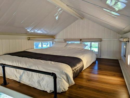 Cama en medio de una habitación con suelo de madera en Tiny House 20 at Grampians Edge en Dadswells Bridge