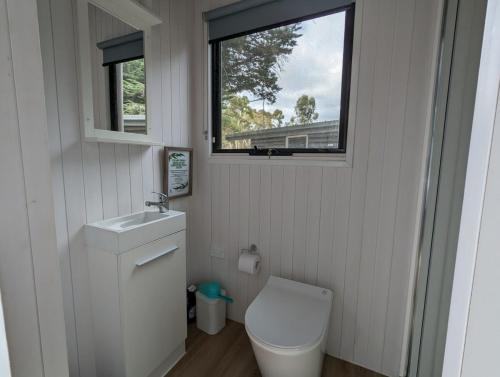 a small bathroom with a toilet and a window at Tiny House 12 at Grampians Edge in Dadswells Bridge