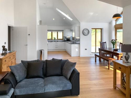 a living room with a couch and a kitchen at Chestnut Lodge in Langley