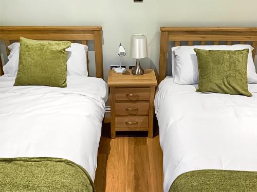 Duas camas sentadas uma ao lado da outra num quarto em Chestnut Lodge em Langley