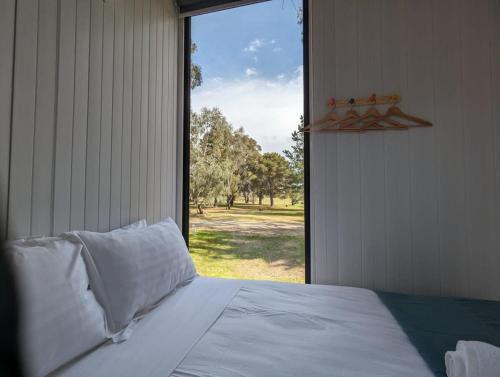 a bedroom with a bed and a large window at Tiny House 15 at Grampians Edge in Dadswells Bridge
