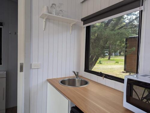 eine Küche mit einem Waschbecken und einem Fenster in der Unterkunft Tiny House 15 at Grampians Edge in Dadswells Bridge