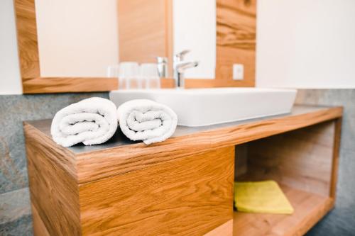 a bathroom with a sink and towels on a counter at Gasthof Hotel Wöhrmaurer in Feldthurns