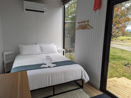 a bedroom with a bed and a large window at Tiny House 19 at Grampians Edge in Dadswells Bridge