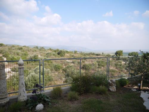 a view of a hill with a fence at Art Apartments in Midrakh ‘Oz