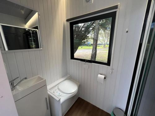 a small bathroom with a toilet and a window at Tiny House 21 at Grampians Edge in Dadswells Bridge