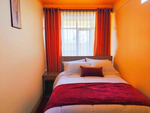 1 dormitorio con 1 cama grande y ventana en COMODORO DEPARTAMENTOS en Oruro