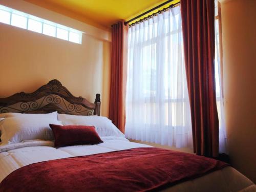 1 dormitorio con 1 cama y ventana grande en COMODORO DEPARTAMENTOS en Oruro
