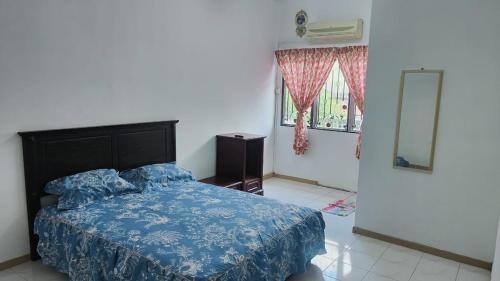 a bedroom with a bed and a mirror and a window at Eing's Homestay - Muslim And Mahram Only in Kajang