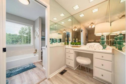 ein Badezimmer mit einer Badewanne, einem Waschbecken, einem WC und einem Spiegel in der Unterkunft Lake Livin' in Hot Springs