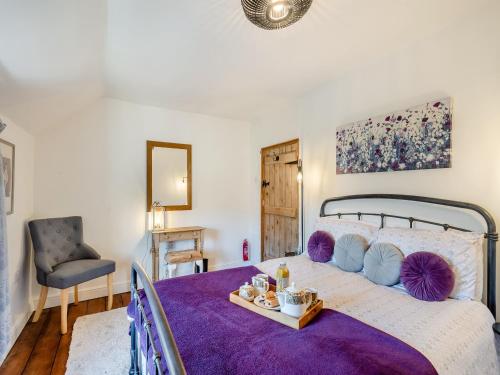 sypialnia z dużym łóżkiem i fioletowym kocem w obiekcie Lavender Cottage w mieście Heacham