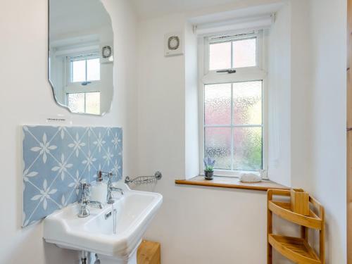 łazienka z umywalką, lustrem i oknem w obiekcie Lavender Cottage w mieście Heacham