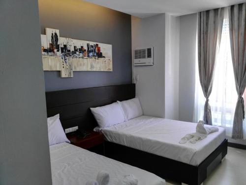 a bedroom with two beds and a teddy bear sitting on the bed at Le Vita Hotel in Santo Domingo