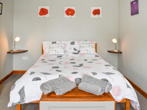 a bedroom with a bed with towels on it at Contention Barn in Perranporth