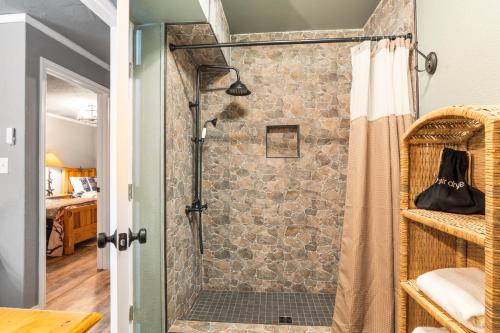 a bathroom with a shower with a stone wall at Salt Block - The Rustic Suite 1 in Bandera