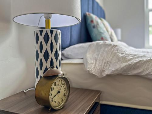 a clock sitting on a table next to a lamp at Apartment 6 - Uk42737 in Whitstable