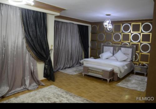ein Schlafzimmer mit einem Bett und einem großen Fenster in der Unterkunft قصر 6غرف حمام سباحه in Madinat as-Sadis min Uktubar