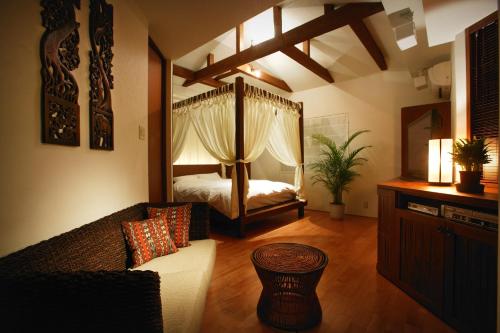 ein Wohnzimmer mit einem Bett und einem Sofa in der Unterkunft Hotel Forest in Ōzu