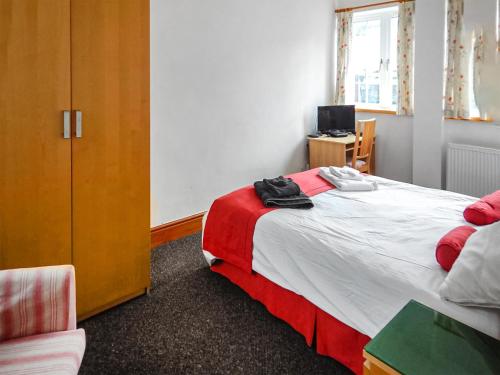 a bedroom with a bed and a cabinet and a desk at The Annex At Is Y Coed in Welshpool