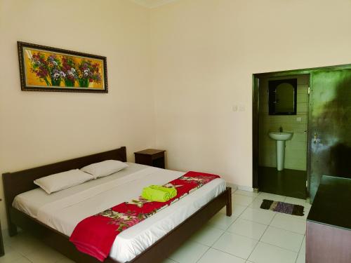 a bedroom with a bed and a sink in it at Berlian Inn Kuta Beach in Kuta