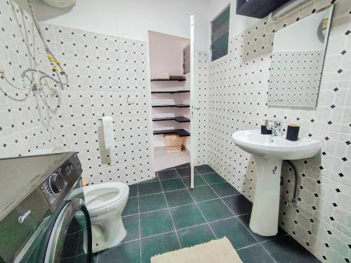 a bathroom with a white toilet and a sink at Duplex Mbote Brazzavile in Brazzaville