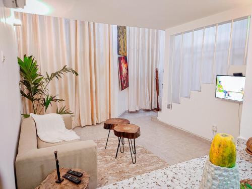 a living room with a couch and a tv at Duplex Mbote Brazzavile in Brazzaville