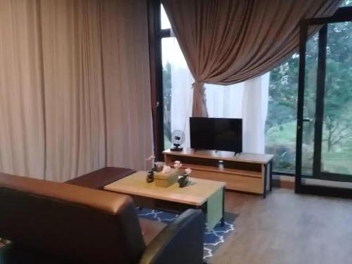 sala de estar con sofá, mesa y TV en Gunung Geulis Camp Area, en Pasirkuda