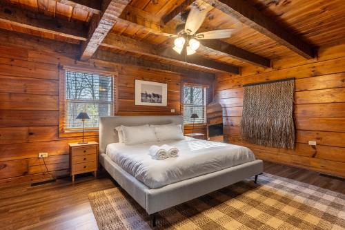 a bedroom with a bed in a log cabin at Dudley II by AvantStay Comfortable Cabin w Hot Tub Views in Pigeon Forge