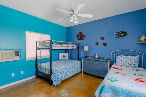 een blauwe slaapkamer met een stapelbed en een plafondventilator bij HavaGetaway Pool Spa BBQ Mountain Views in Lake Havasu City