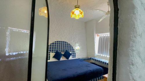 a bedroom with a blue bed and a window at Sol y Mar. Delfines in Ixtapa