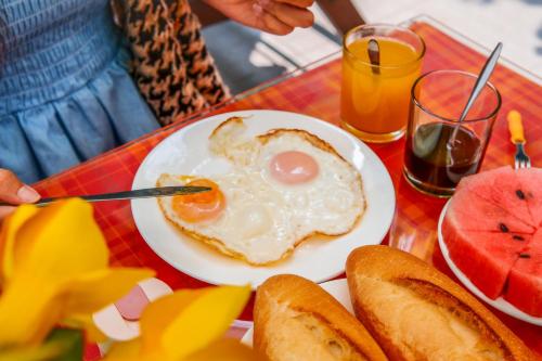 a plate of eggs and bread on a table at Oleander Garden Homestay in Hoi An