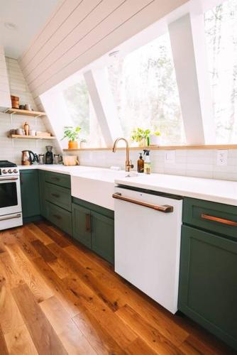 a kitchen with green cabinets and a white sink at Dunlap Hollow A-Frame in Rockbridge