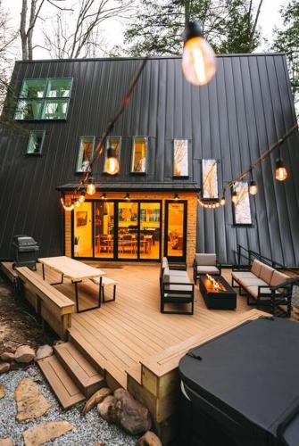 a house with a wooden deck with chairs and tables at Dunlap Hollow A-Frame in Rockbridge
