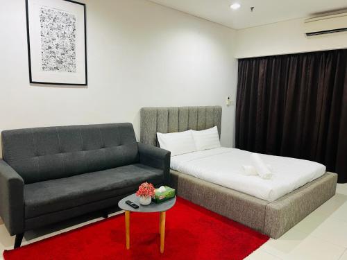 Cette chambre comprend un canapé, un lit et une table. dans l'établissement Mercu Summer Suites Kuala Lumpur Bukit Bintang by Classy, à Kuala Lumpur