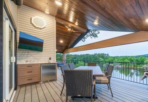 eine Terrasse mit einem Tisch und Stühlen sowie eine Küche in der Unterkunft Ridgeview Haven in Hot Springs