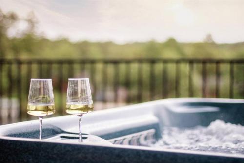 zwei Gläser Weißwein im Whirlpool in der Unterkunft Ridgeview Haven in Hot Springs
