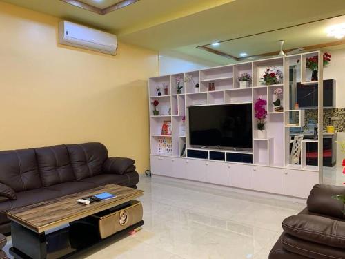 ein Wohnzimmer mit einem Sofa und einem Flachbild-TV in der Unterkunft Saina Dive Residence - Fuvahmulah, Maldives in Fuvahmulah