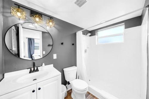 a bathroom with a white sink and a mirror at Stylish - Water View Condo - Palm Wave Says in Coconut Creek