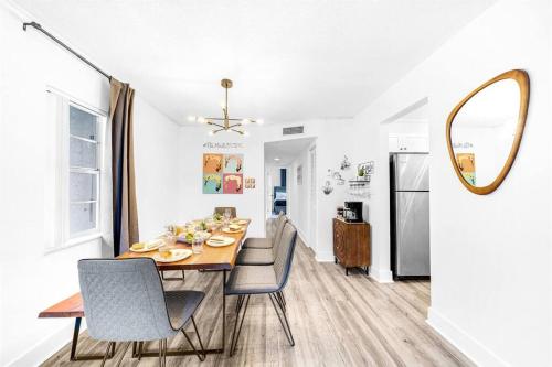 a dining room with a table and chairs and a mirror at Stylish - Water View Condo - Palm Wave Says in Coconut Creek