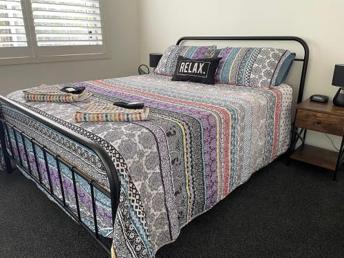 Una cama con edredón en un dormitorio en The Bedside Manor, en Russell Island