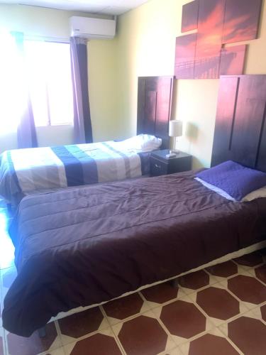 - une chambre avec 2 lits et une fenêtre dans l'établissement Estrada House, à Santa Ana