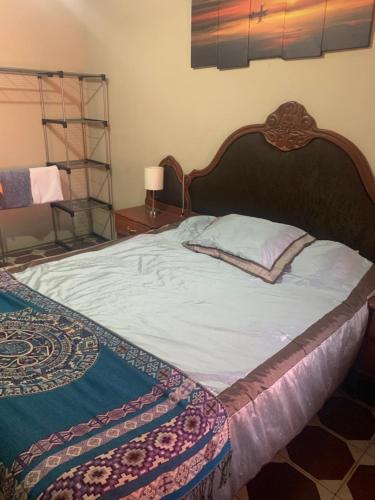 - un grand lit avec une tête de lit en bois dans une chambre dans l'établissement Estrada House, à Santa Ana