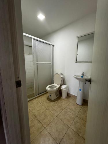 a bathroom with a shower and a toilet and a sink at Hotel Balcones del Sinu in Lorica