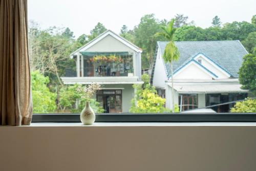 a vase sitting on a window sill with a house at Hajime Homestay Hue in Hue