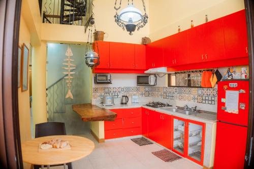 a kitchen with red cabinets and a wooden table at Cozy Baguio House - Outlook Drive (DOT accredited) in Baguio